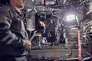 Cropped head portrait of mechanic and engineer wearing uniform working inside airplane with aviation tools and equipment